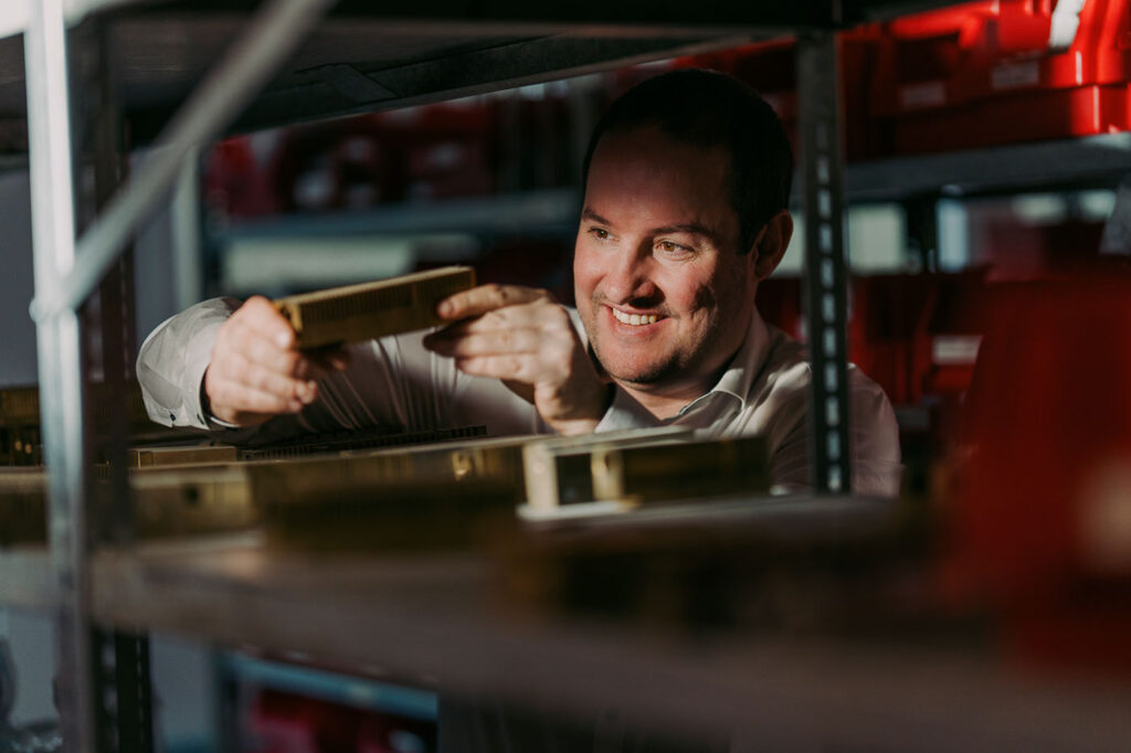 Stefan hält ein Stück von der Maschine in der Hand