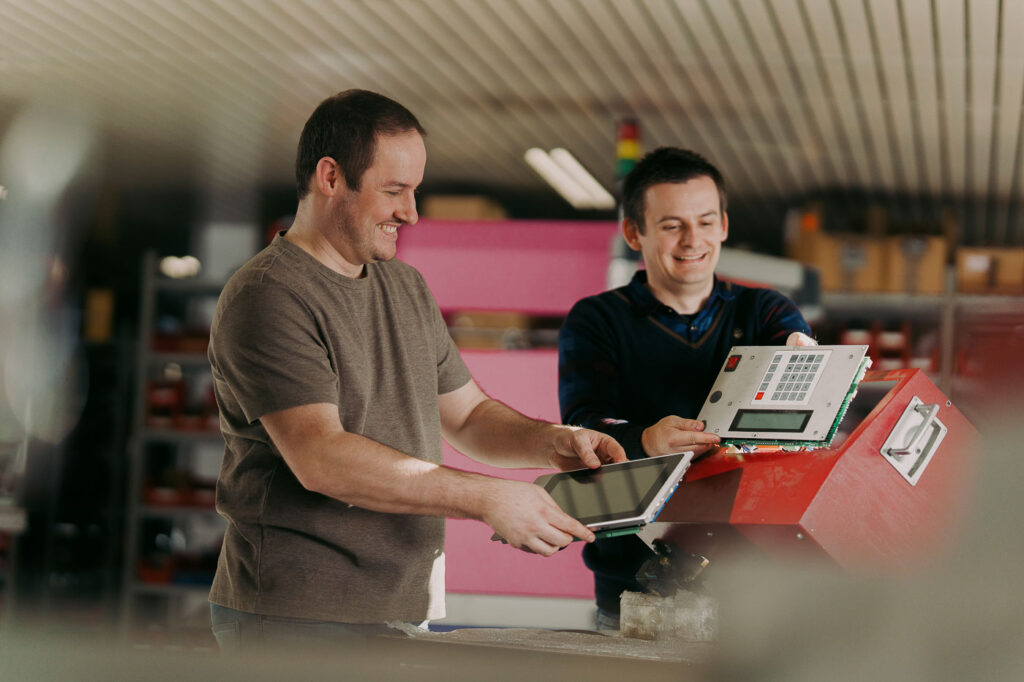 Zwei Männer arbeiten an einer Maschine