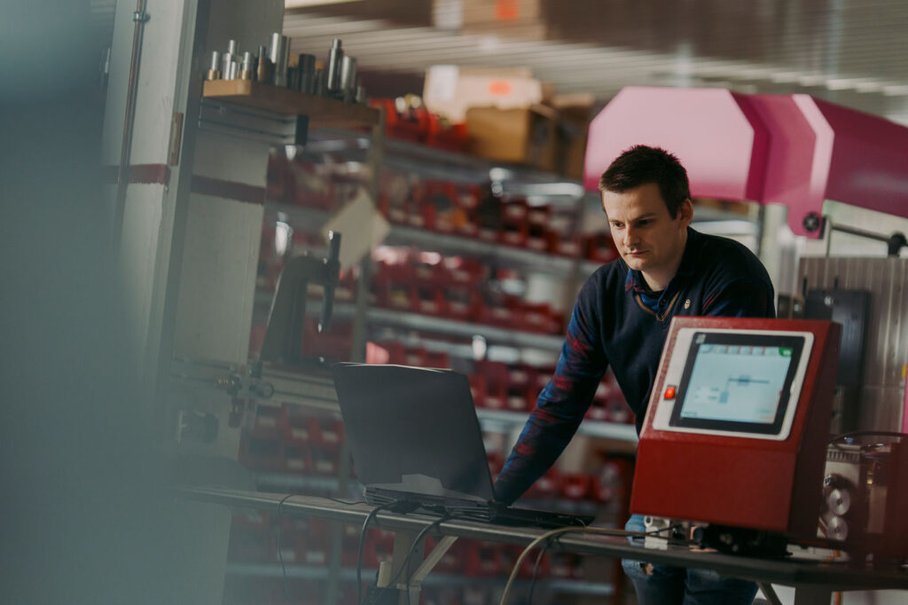 Maschine im steht im Vordergrund und im Hintergrund steht eine Person